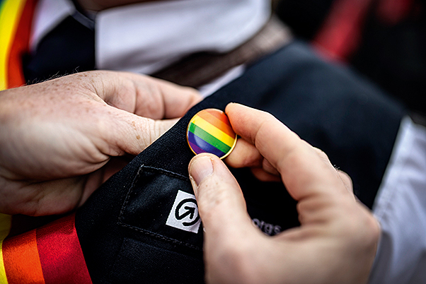 Pride-pin sätts fast på en medarbetares väst