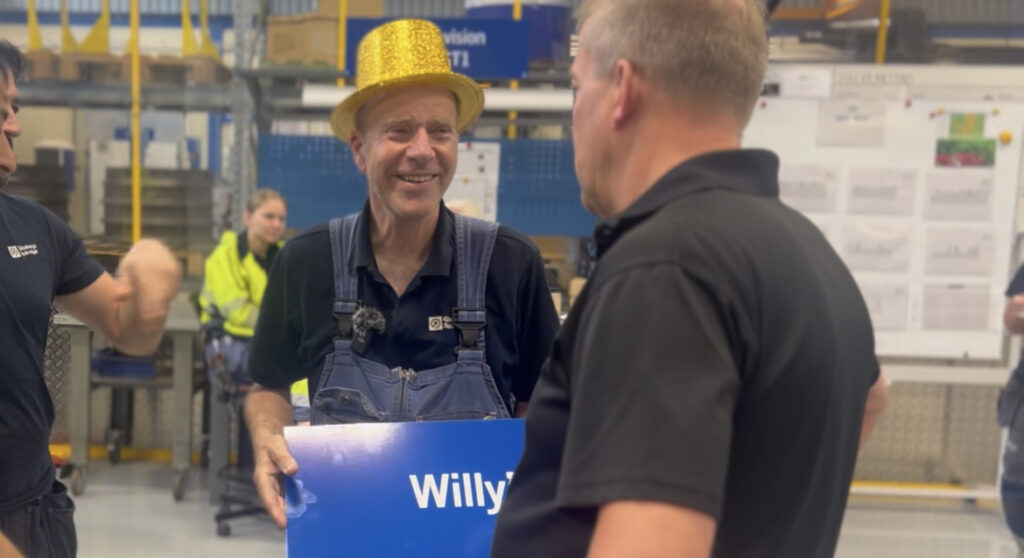 Willy Berntsson i guldig hatt som håller i en skylt