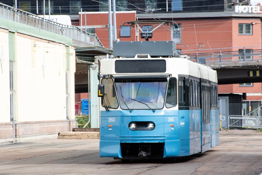 En blå och vit spårvagn av modell M31B står parkerad vid Göteborgs Spårvägars depå Rantorget. På vagnen står numret 360. Vagnen syns framifrån. Dörrar och fönster har svart inramning